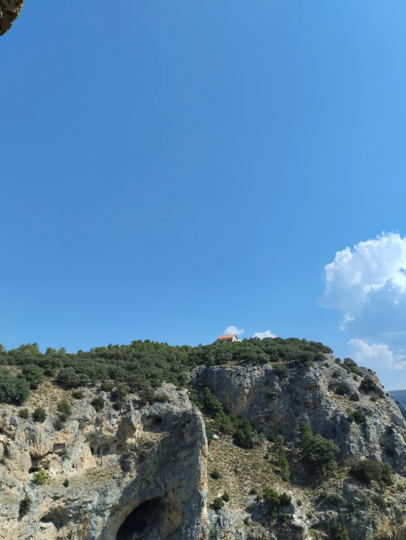 Casa solitaria sobre un cortado de roca bajo un cielo azul intenso